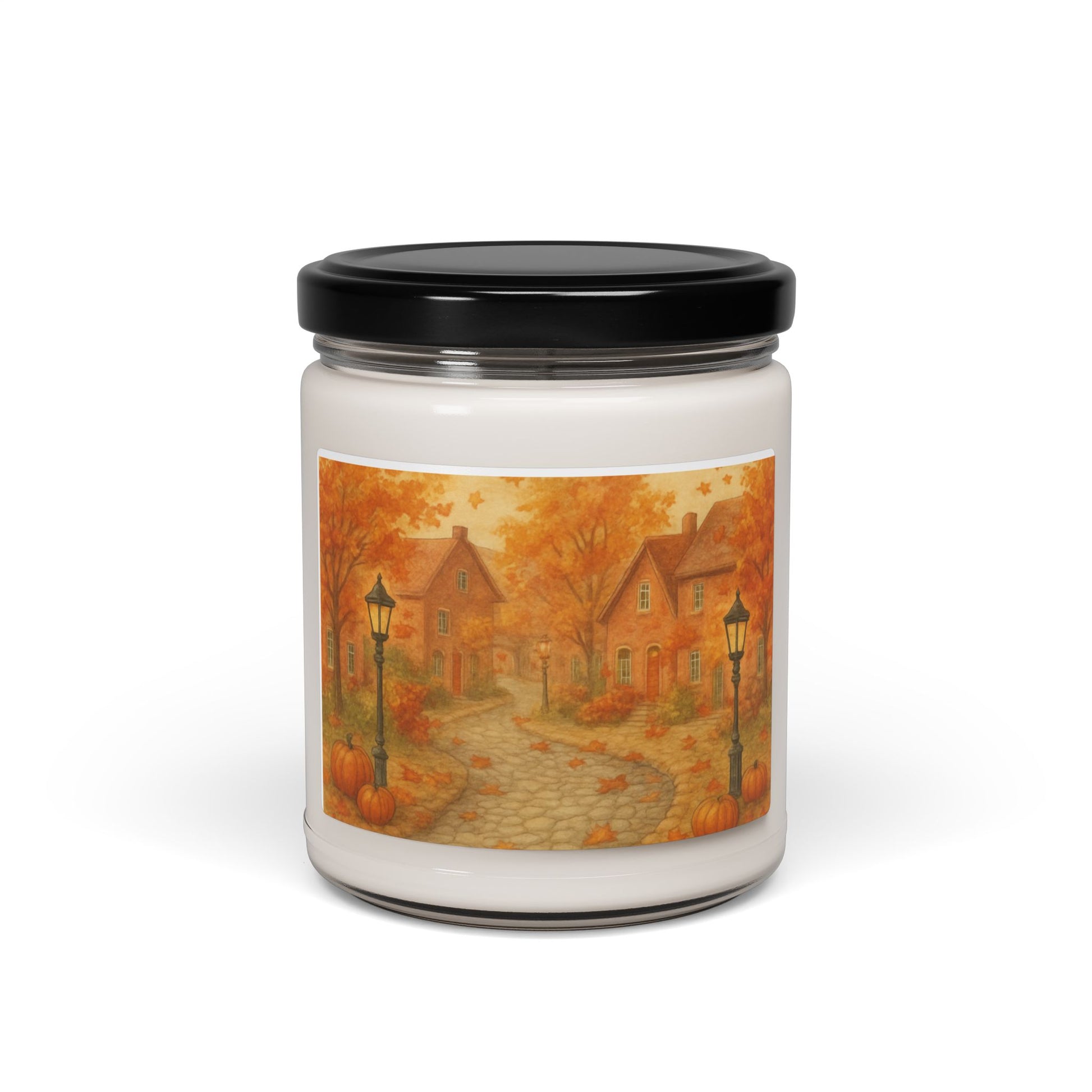 Candle with a black lid and autumn-themed label featuring houses and pumpkins on a white background.